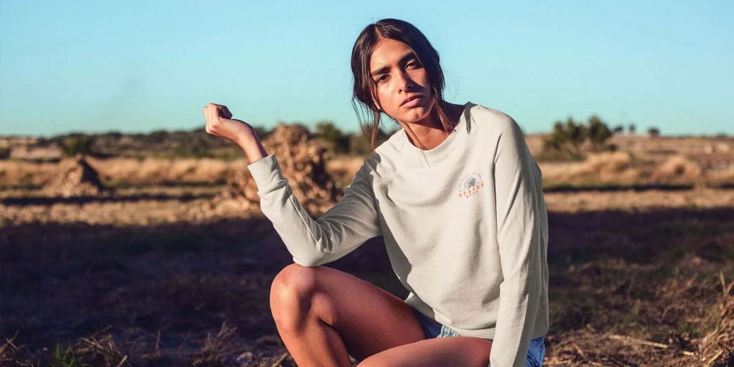 Model wearing APACHE STAR fashion sweatshirt in outdoor setting.