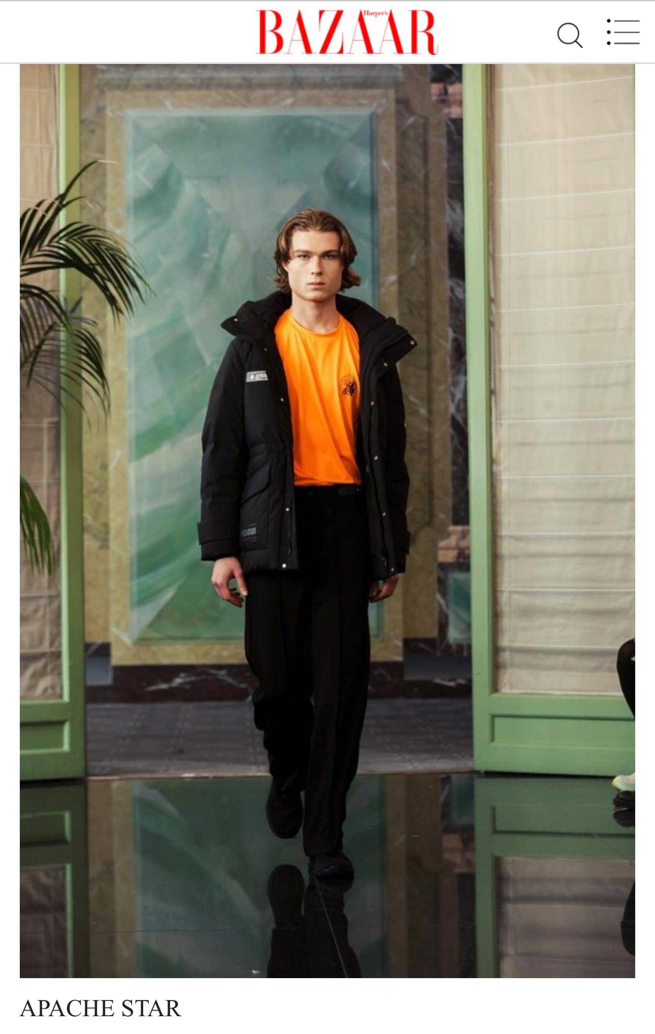APACHE STAR® featured in Harpers Bazaar showcasing the Burning Battalion Performance Shirt in bright orange styled with American Anchorage Down Jacket and black pants at Paris Fashion Week 2025, ideal for sun protection and sportswear.