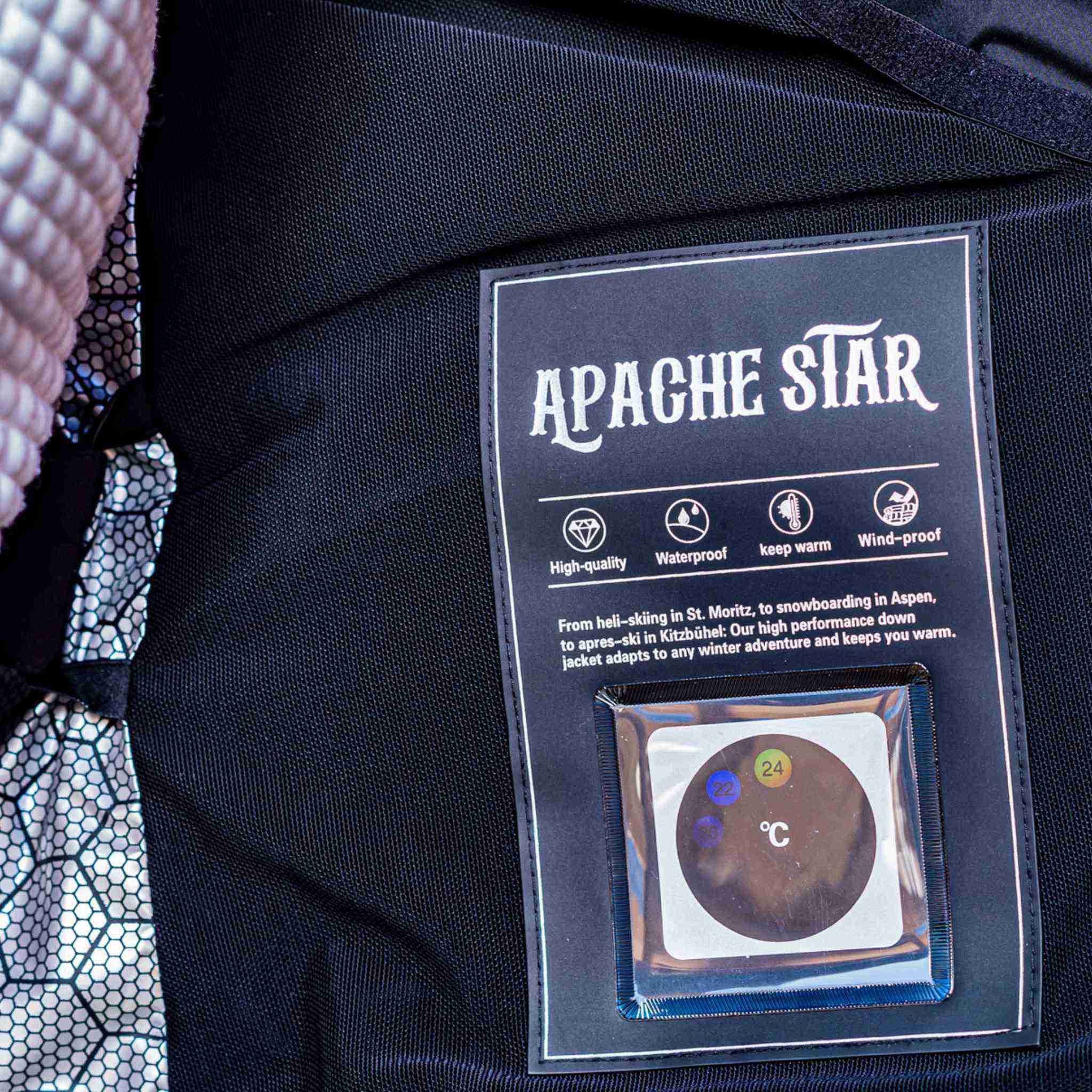 Interior label of Trident Trooper Down Coat by APACHE STAR showing waterproof, windproof, and thermometer, ideal for alpine and winter sports use.