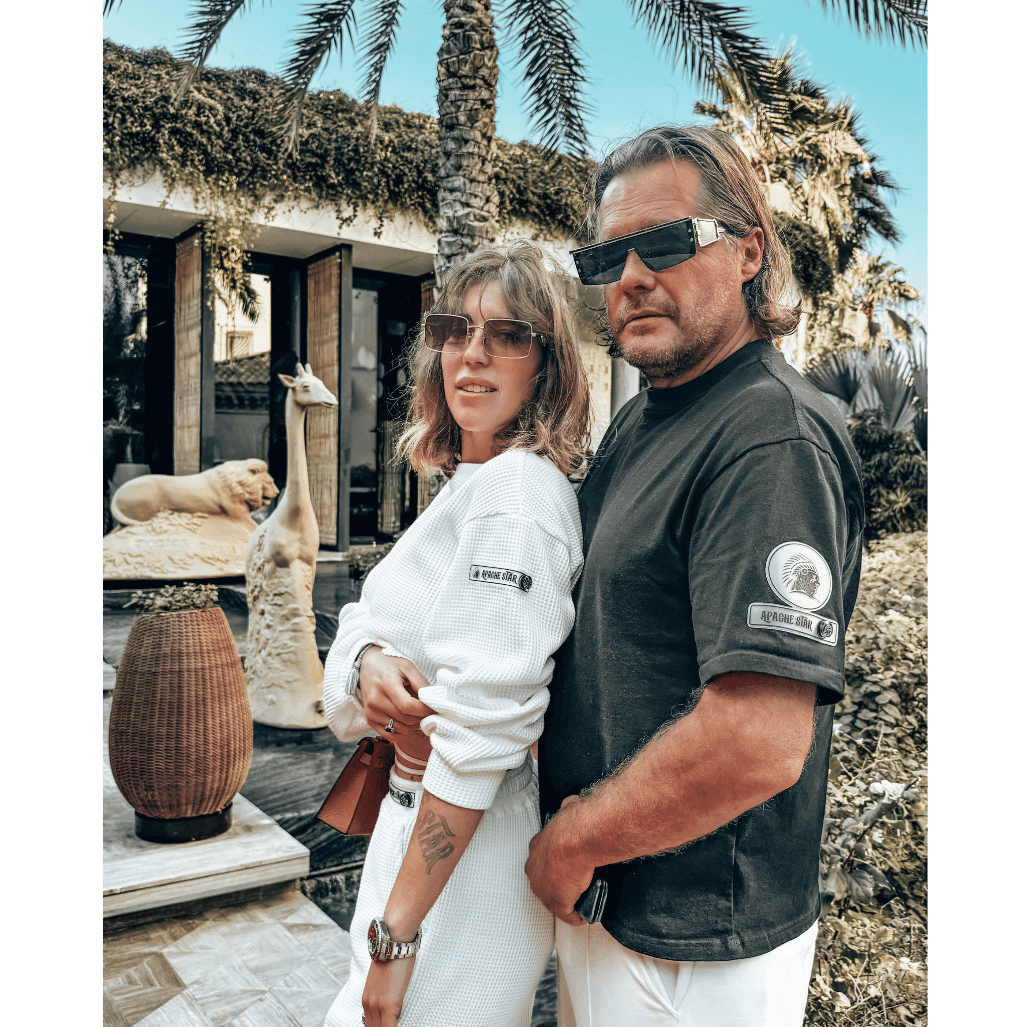 Roger Klüh & Jessica Frühbrodt posing in Iconic APACHE STAR Miami Tees, showcasing fashion-forward design and breathable cotton for summer.
