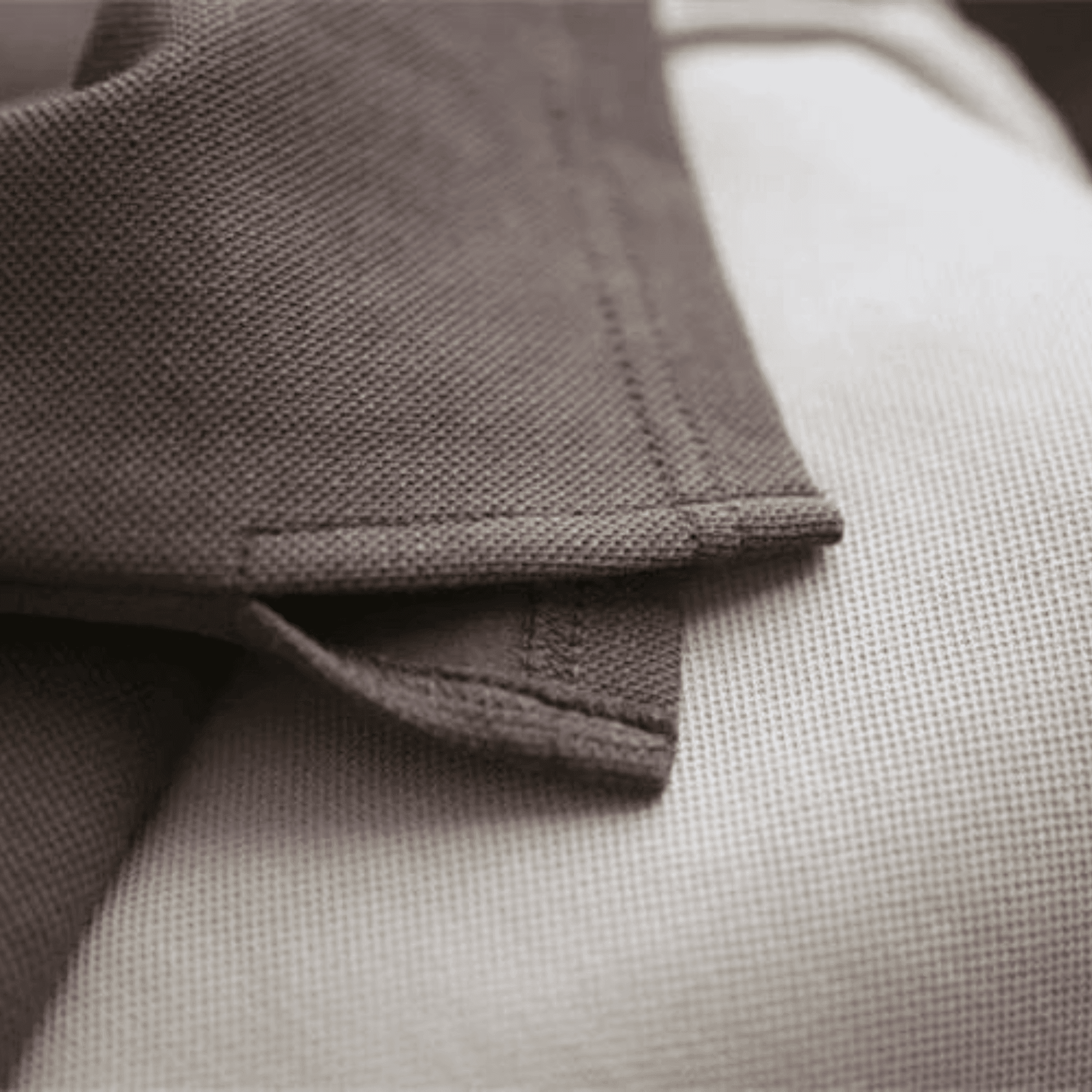 Close-up of BOXY TEE 'MANHATTAN' by APACHE STAR hem stitching in brown, highlighting durability and clean craftsmanship.