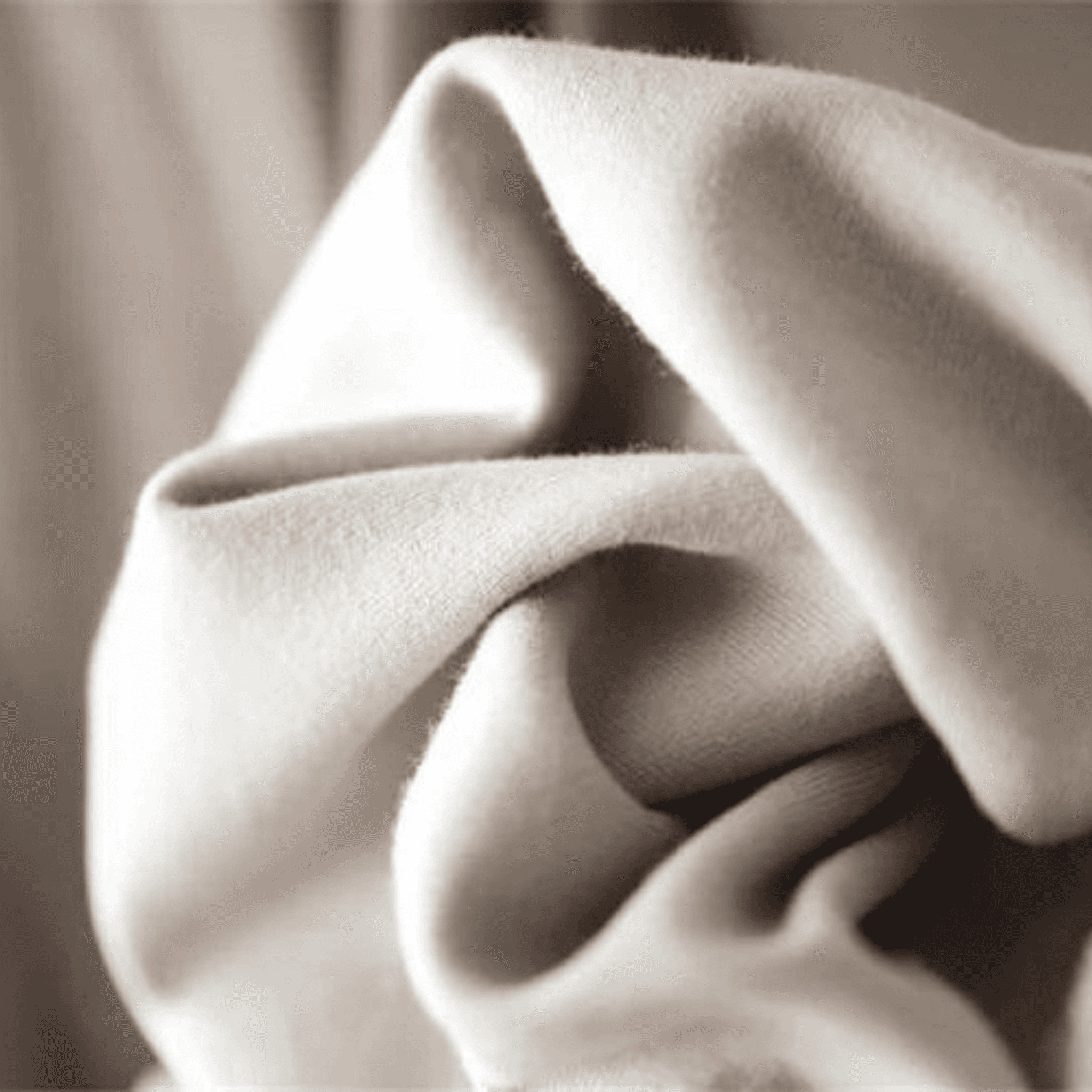 Close-up of BOXY TEE 'MANHATTAN' by APACHE STAR fabric in beige, highlighting smooth texture and sustainable cotton quality.