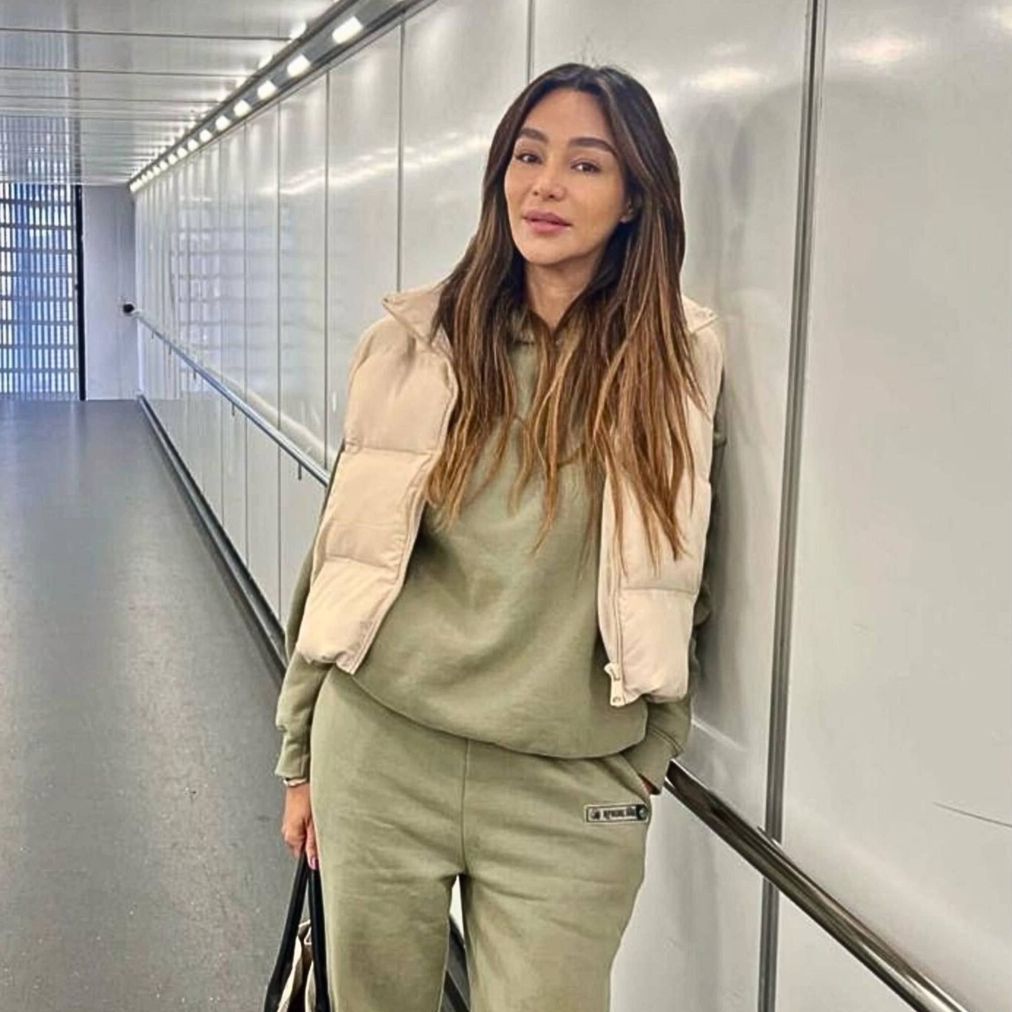 ICONIC PANTS 'DUBAI' by APACHE STAR worn by Verona Pooth in military green, styled with matching hoodie and beige vest for a luxury casual look in men's and women's fashion.