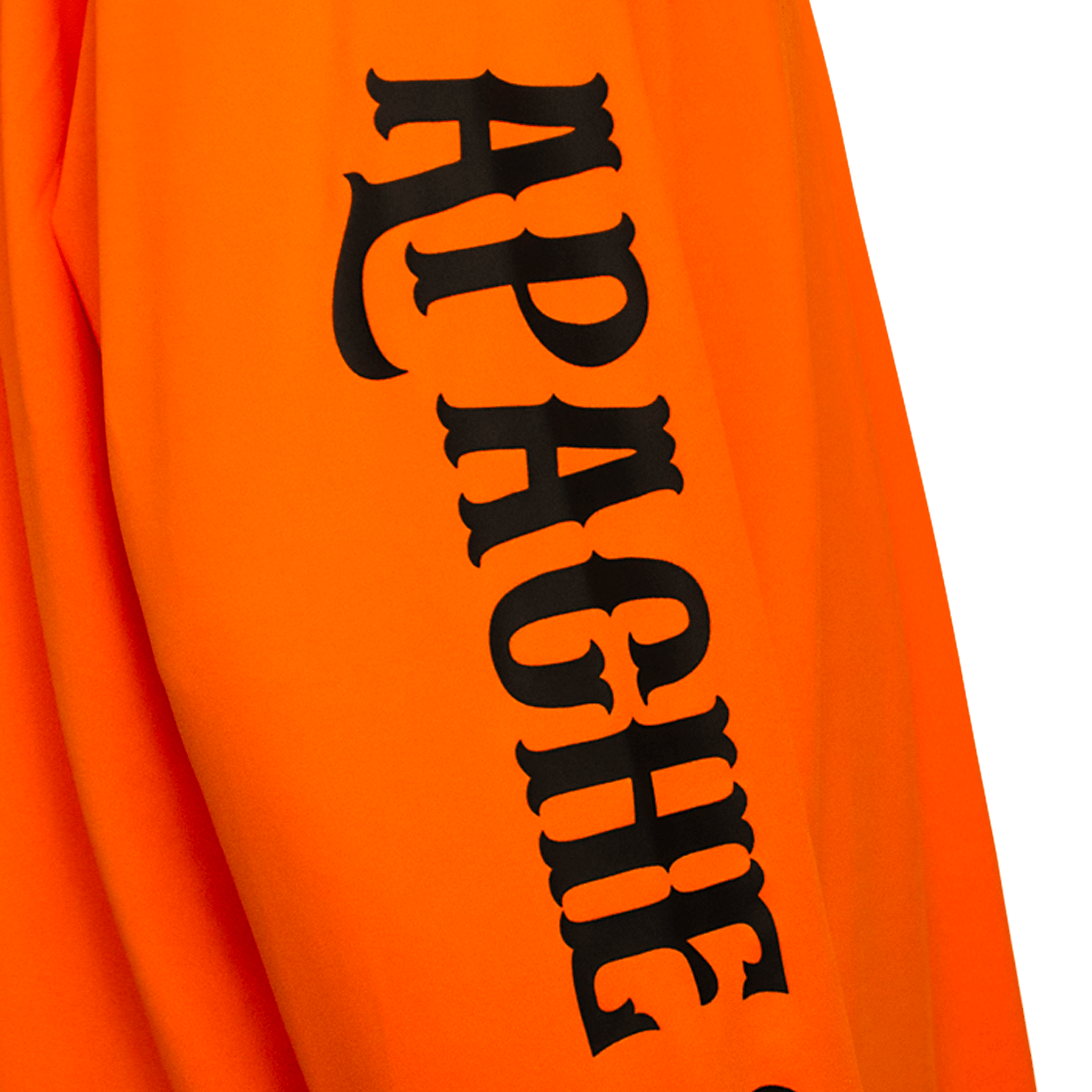 Detail of APACHE STAR branding on the sleeve of the Burning Battalion Longsleeve Shirt, printed in bold black gothic font on orange fabric.