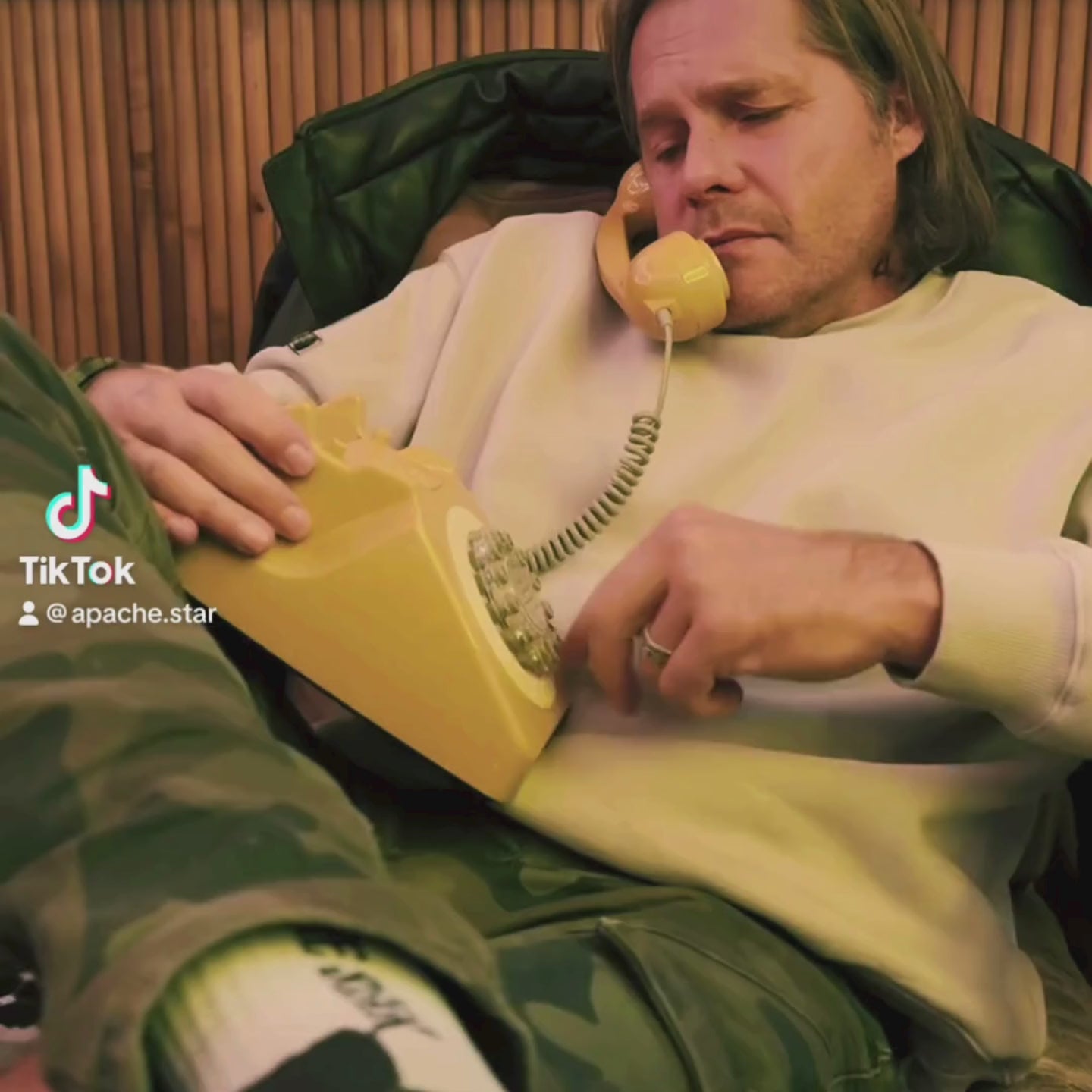 Monaco Sweatshirt in cream by Apache Star, worn by Roger Klüh using vintage yellow phone. Cozy fleece texture with military-inspired design.