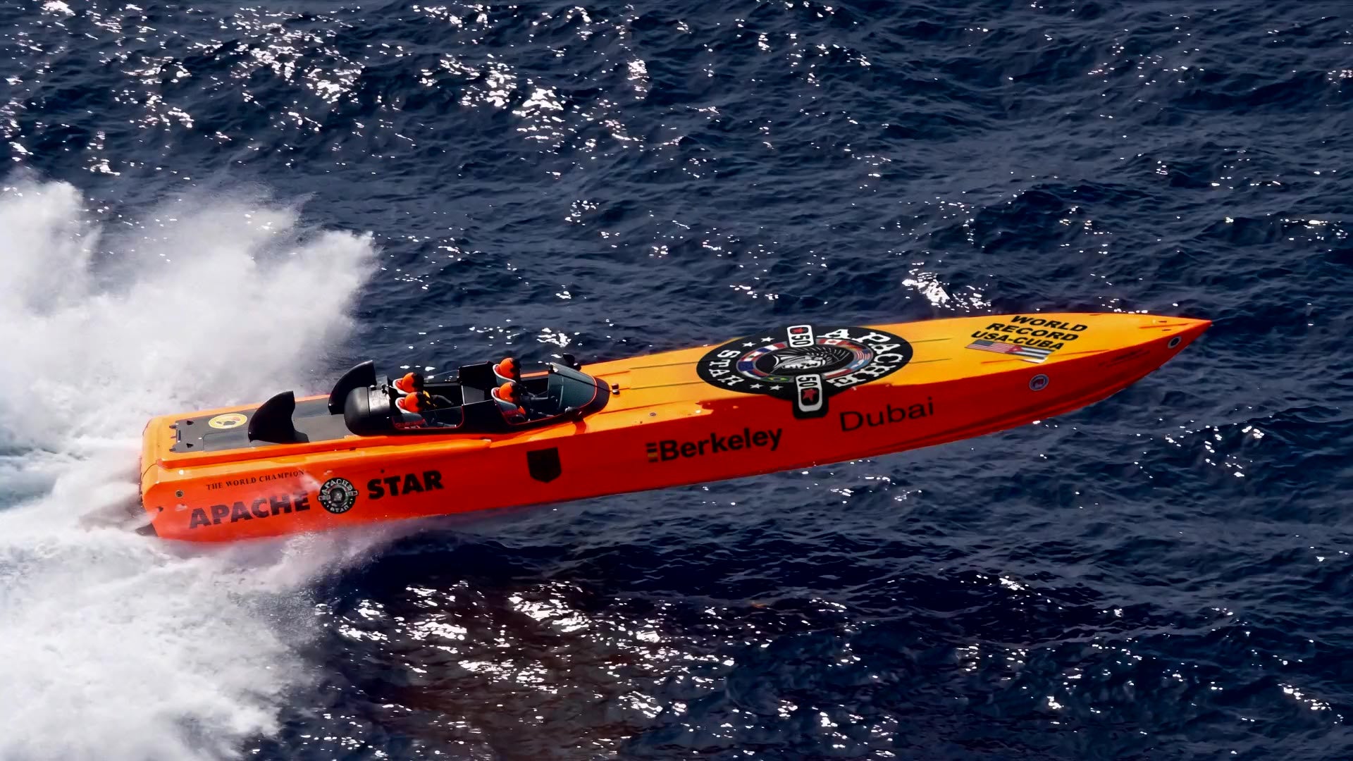 The orange powerboat APACHE STAR at full speed on open water, seen from above