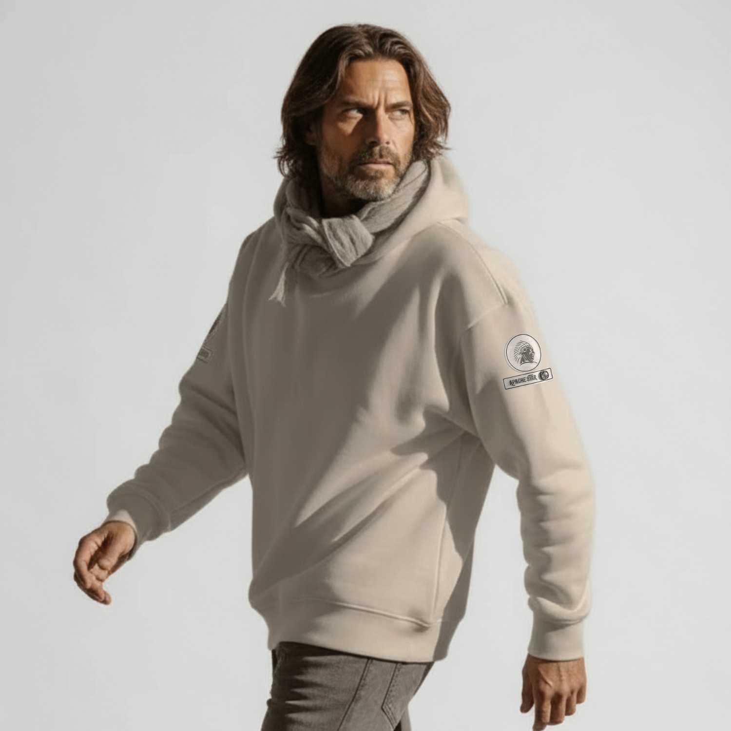 Man in beige hoodie with logo, fashion shoot, studio background