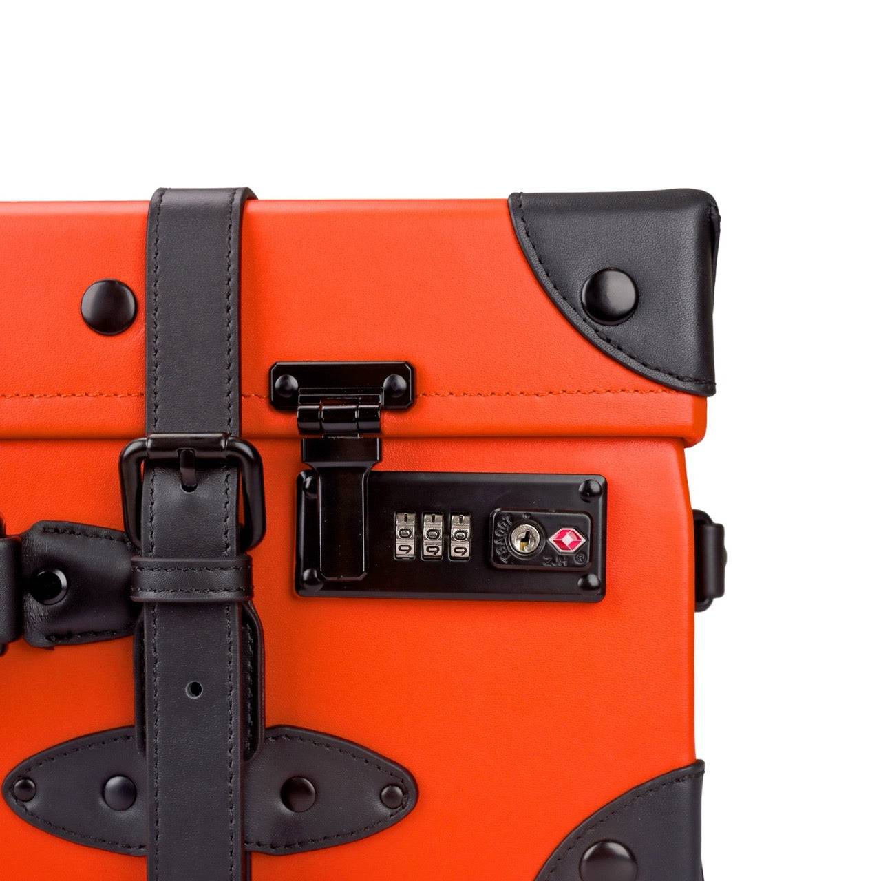Detailed view of APACHE STAR® Signature Orange trunk luggage corner with TSA lock and reinforced black leather trim for durability and elegance.