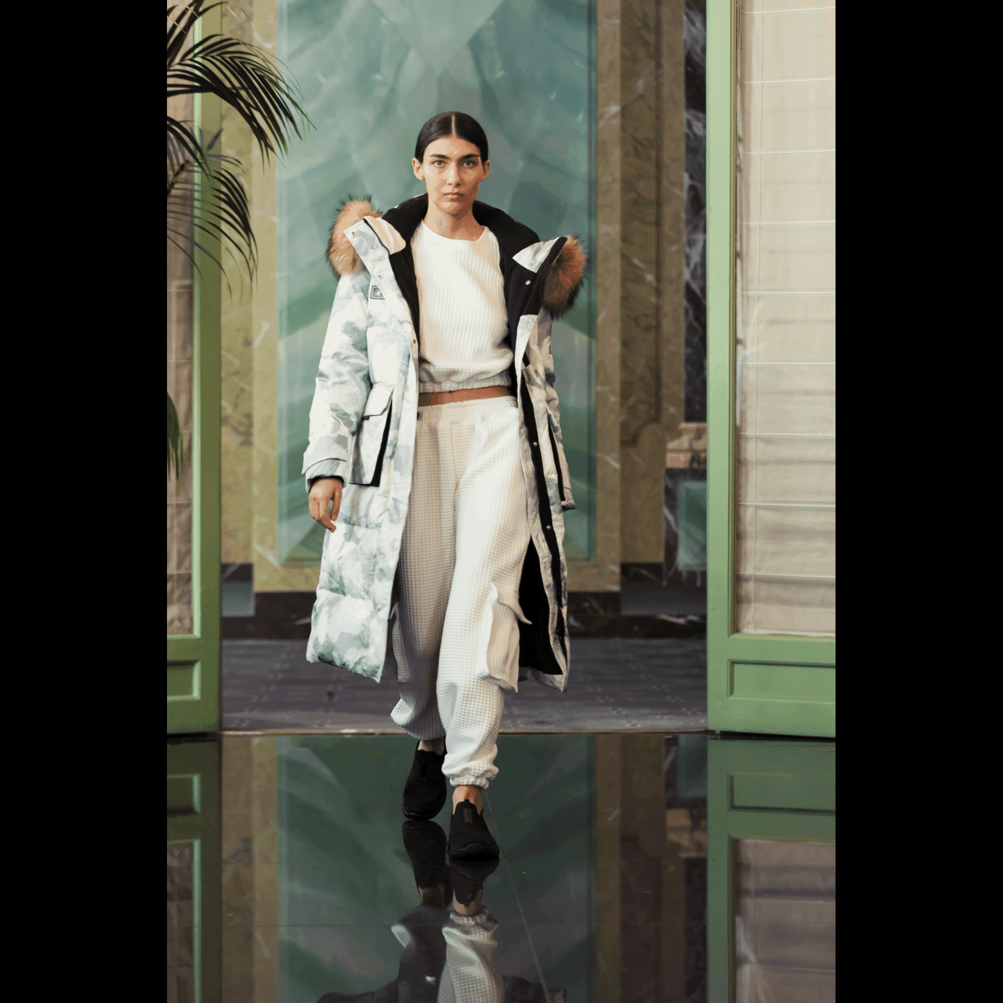 Model walking runway in Brigade Breeze Down Coat by APACHE STAR in white camo, paired with white loungewear for a chic tech wear look at Paris Fashion Week.