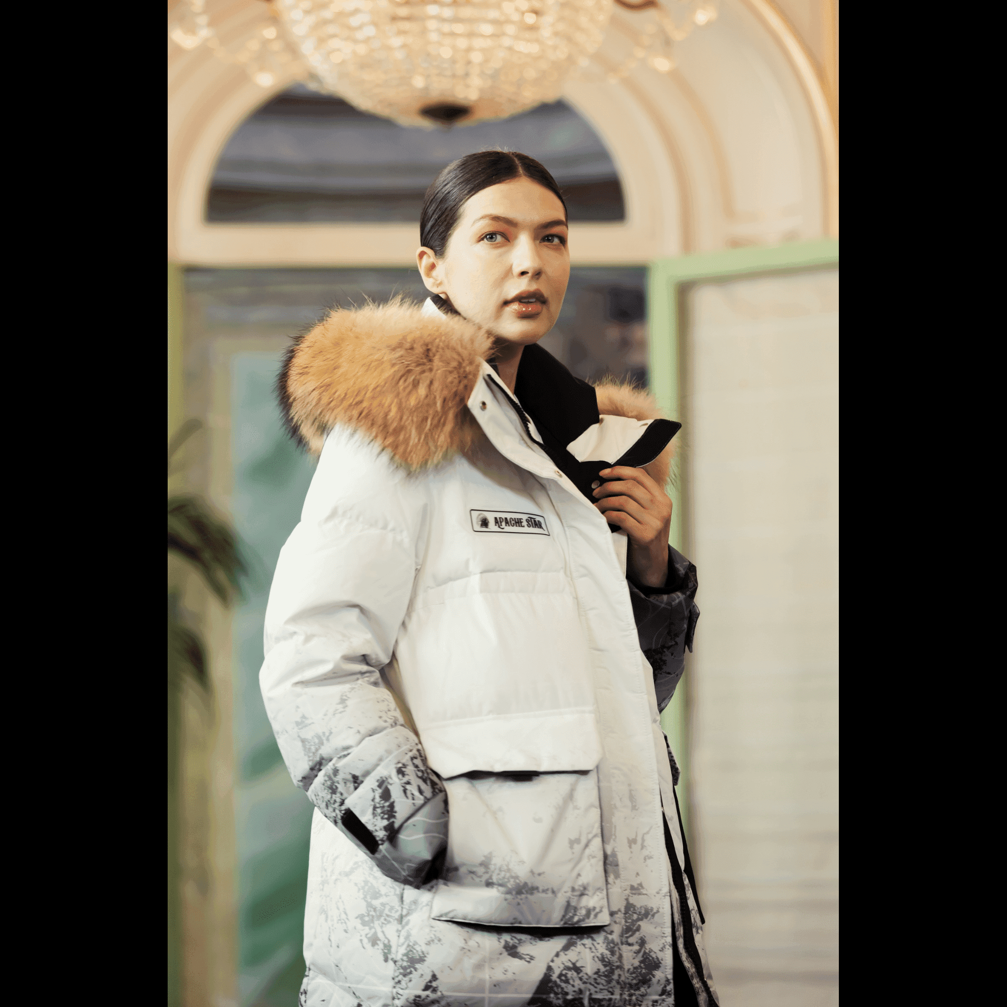 Close-up of woman wearing Trident Trooper Down Coat by APACHE STAR with fur hood at Paris Fashion Week, emphasizing premium winter style and warmth.